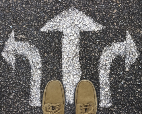 pieds sur une route, flèches de direction